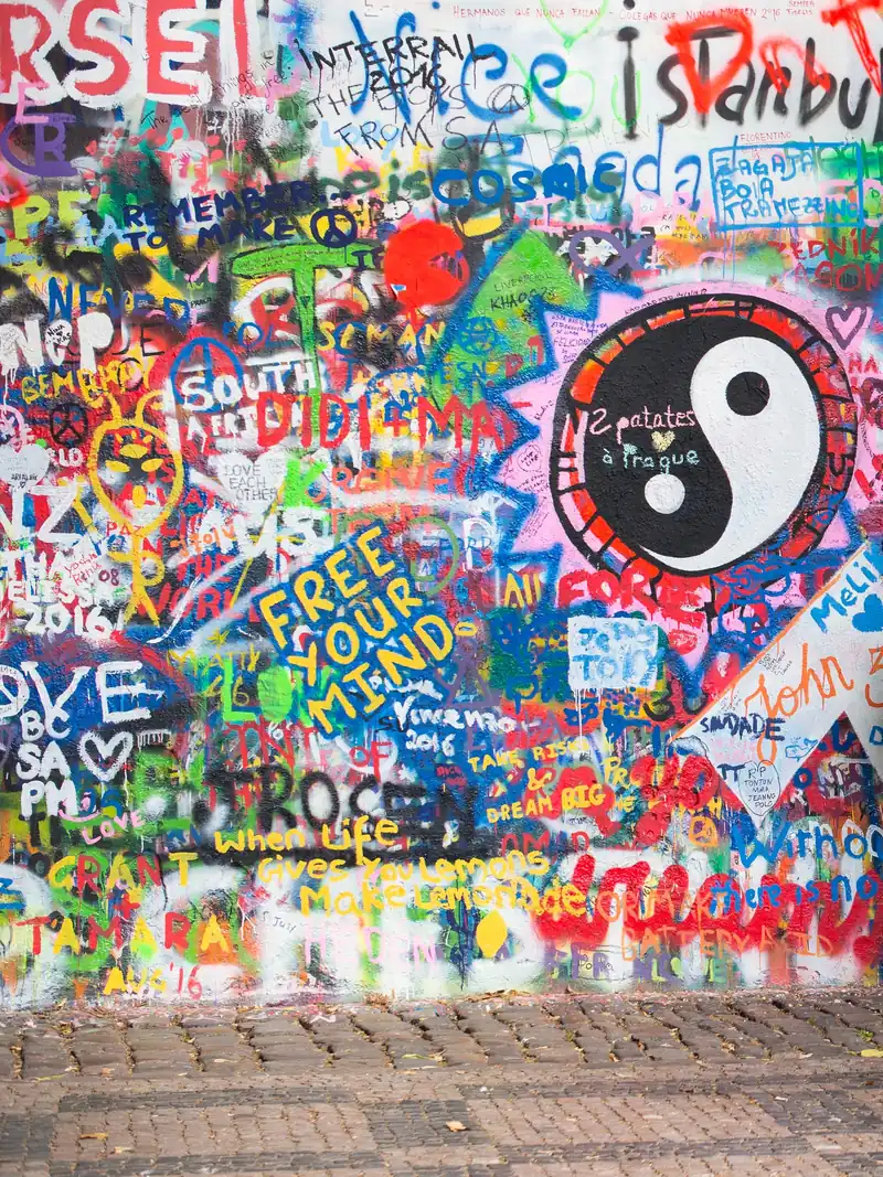 The Lennon Wall in Prague, covered in painted words, hearts and a large yin-yang